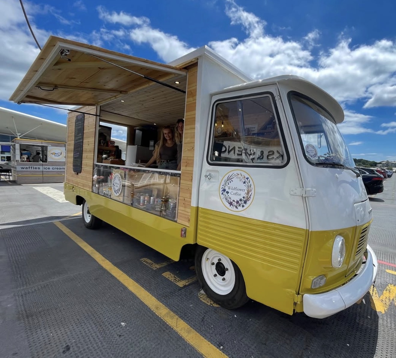 The yellow and cream Wildflower Coffee Peugeot van, open and serving